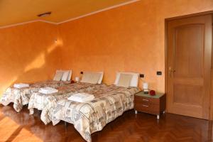 sypialnia z 2 łóżkami i drewnianą podłogą w obiekcie Welcome Garden w mieście Romano di Lombardia