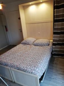 a bed with two pillows on it in a room at Charmant studio bord de mer in Ouistreham