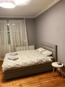 a bedroom with a bed and a table at Eleven apartment in Koszalin