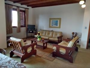 a living room with a couch and a table and chairs at Hotel San Carlos in Carlos Barbosa