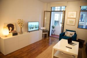 sala de estar con TV y silla azul en Casa Andrea, en Pamplona