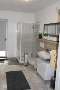 a bathroom with a sink and a toilet and a shower at Casa Feliz in Bremen