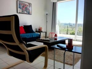 a living room with a couch and a table and a chair at STUDIO POSEIDONIA apartment 75sqm CORINTH CANAL in Kórinthos