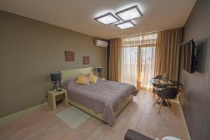 a bedroom with a bed and a desk and a television at Apartment Batumi Weekend in Batumi