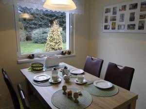 a dining room table with a christmas tree in the window at Sommerhaus im Grünen in Berlin