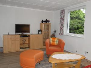 a living room with a tv and two chairs and a table at Sommerhaus im Grünen in Berlin