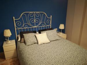 - une chambre dotée d'un lit avec un mur bleu dans l'établissement Apartamento La Muralla de Teruel, à Teruel