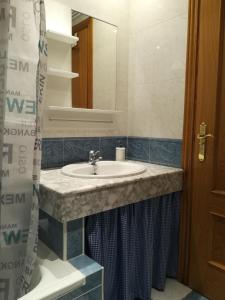 La salle de bains est pourvue d'un lavabo et d'un miroir. dans l'établissement Apartamento La Muralla de Teruel, à Teruel