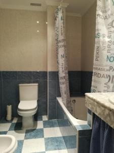 La salle de bains est pourvue de toilettes, d'une baignoire et d'un lavabo. dans l'établissement Apartamento La Muralla de Teruel, à Teruel