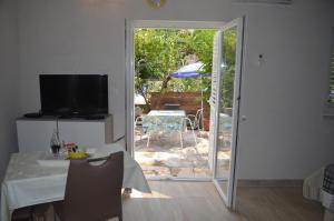 uma sala de estar com uma mesa e uma porta de vidro deslizante em Stella Maris Cottage With Garden em Bol