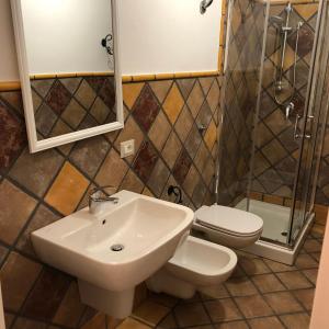 une salle de bain avec un lavabo, des toilettes et une douche dans l'établissement Casa della Nonna, à San Giovanni Suergiu