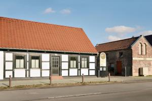 a building with an orange roof next to a church at FeWo Jung in Falkensee