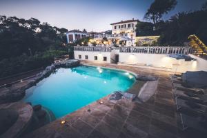 a large swimming pool in front of a house at Hotel Villa Margherita in Quercianella
