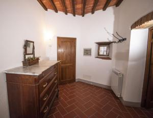 Cette chambre dispose d'une commode et d'une porte en bois. dans l'établissement Casa Selvolini - VOLPAIA, à Radda in Chianti