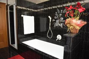 a black tiled bathroom with a sink and a shower at Welcome Garden in Romano di Lombardia