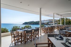 アギオス・ステファノスにあるAlkistis Beach Hotel - Adults Onlyのテーブルと椅子が備わり、海の景色を望むレストラン