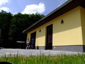 ein gelbes Gebäude mit Stühlen und einem Tisch im Freien in der Unterkunft Ferienhaus "Kräuterhexe" mit Wasserbett 200x200cm in Wernigerode