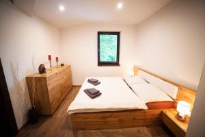 1 dormitorio con cama de madera y ventana en Apartmán Ježko en Tale