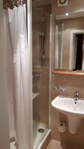 ein Bad mit einem Duschvorhang und einem Waschbecken in der Unterkunft Central Hotel-Apart München in München