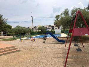 a playground with a slide and children playing at Pis la rapita in Alcanar