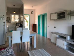 a kitchen with a dining table and white chairs at Pis la rapita in Alcanar