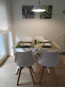 une table à manger avec quatre chaises, une table et une lampe dans l'établissement Apartamento OD, à Piedras Blancas