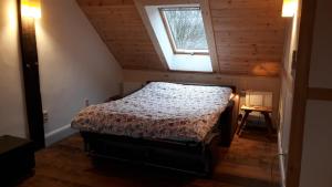 a bedroom with a bed in a attic with a window at Lindenhof in Wahrenberg