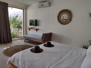 チャングーにあるVilla Manikのベッドルーム1室(ベッド1台、帽子2つ付)