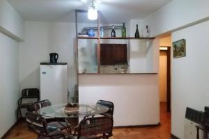 Un comedor con una mesa de cristal y sillas. en Edificio Independencia Lavalle 35, en Mendoza