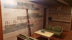 una camera con una parete in legno, una scopa e un tavolo di Hotel Mira a Sedrun