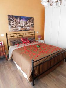 a bedroom with a large bed with red flowers on it at Le Giare House in Grezzana