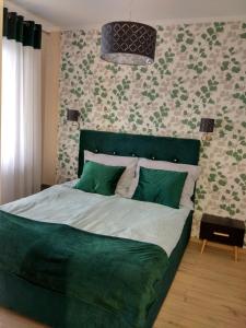 ein Schlafzimmer mit einem großen Bett mit grüner Bettwäsche in der Unterkunft Apartament Zielono Mi in Kołobrzeg