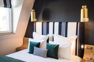 a bedroom with a bed with white and green pillows at Hôtel & Spa Madison Saint Jean de Luz in Saint-Jean-de-Luz