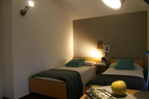 a room with two beds and a table with a desk at Residence Gemma in Riva del Garda