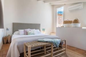 a white bedroom with a large bed and a window at Ca Sa Padrina in Sóller