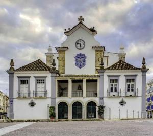 un gran edificio blanco con un reloj en él en Mobile Home 1 - Olhão, en Quelfes