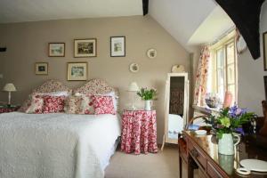 a bedroom with a white bed with red pillows at Brook Farmhouse in Exeter