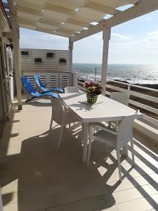 a white table and chairs on a balcony with the ocean at Vista Mare tra i luoghi di Montalbano in Punta Secca