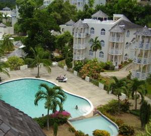 欧丘里欧#D1 castle STUDIO WIFI KING bed Ocho Rios Jamaica的大楼前游泳池的空中景致