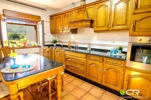 a kitchen with wooden cabinets and a black counter top at NATURAL ENVIRONMENT AND BEACHES-CTR in Valmaior