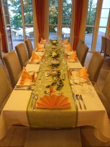 a long table with plates and silverware on it at Parkstadthotel Bad Muskau in Bad Muskau