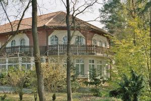 a large house with a balcony on the side of it at Parkstadthotel Bad Muskau in Bad Muskau