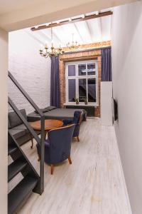 Un comedor con mesa y sillas y una ventana. en MoHo L, en Wroclaw