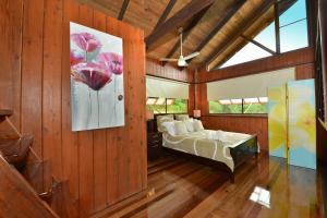 1 dormitorio con 1 cama y una pintura en la pared en Tea Tree Cottage, en Diwan