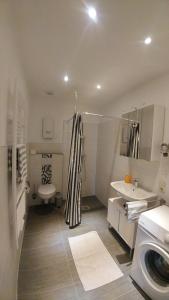 a white bathroom with a sink and a toilet at Moderne Ferienwohnungen am Kurpark - zentral, ruhig & nah am Edersee in Bad Wildungen +12 photos