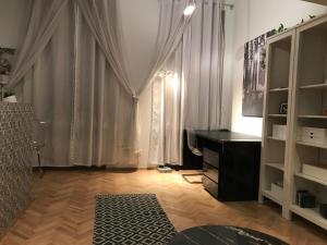 a room with a desk and a dresser and curtains at Elegant Apartment in Budapest
