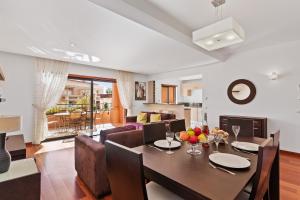 een eetkamer en een woonkamer met een tafel en stoelen bij Luxury Holiday 2-bedroom Apartment Praia da Luz in Luz