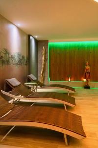 - un groupe de chaises dans une pièce dotée de lumières vertes dans l'établissement Au Soleil, Hôtel Restaurant & Spa, à Valff