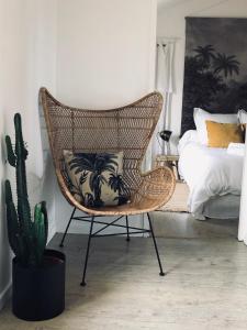 a rattan chair in a bedroom with a cactus at Appartement Casalea - Casadibastia - Bastia centre in Bastia