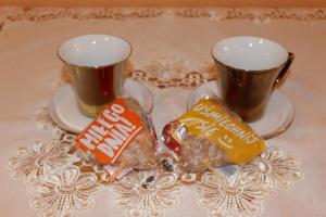 カルパチにあるPokój Kameralny- De Luxe z oddzielnym wejsciemのお茶2杯と食べ物が載った皿